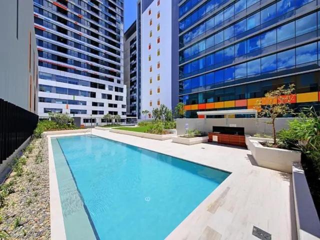 a large swimming pool in front of a building at Bedroom & Private Bathroom in Modern Inner Brisbane Apartment in Brisbane