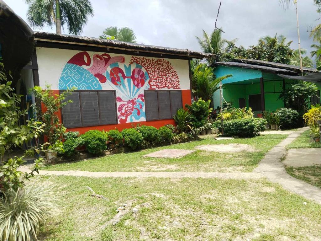 a house with a painting on the side of it at Charity Pension House in San Vicente
