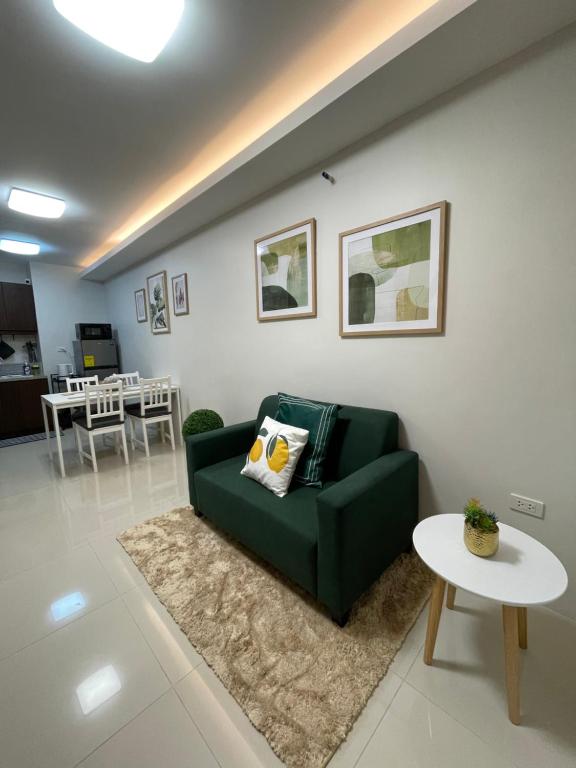 sala de estar con sofá verde y mesa en FLY & REST GUESTHOUSE - Mactan-Cebu International Airport, en Lapu Lapu City