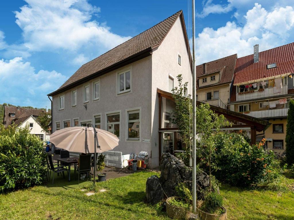 a house with a table and an umbrella in the yard at Cosy apartment with sauna in the Black Forest in Sulz am Neckar