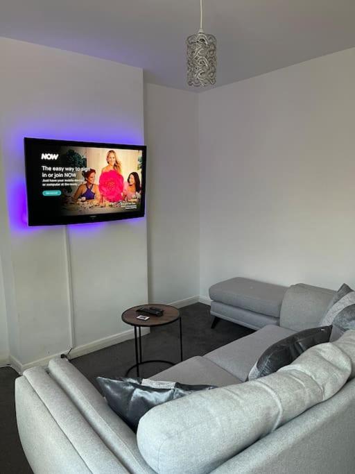 sala de estar con sofá y TV de pantalla plana en Big house with garden en Gillingham