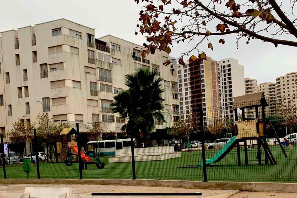une aire de jeux dans un parc d'une ville avec de grands bâtiments dans l'établissement F5 -5 bedrooms Apt- Residence Hasnaoui avec parking Oran Algeria, à Oran