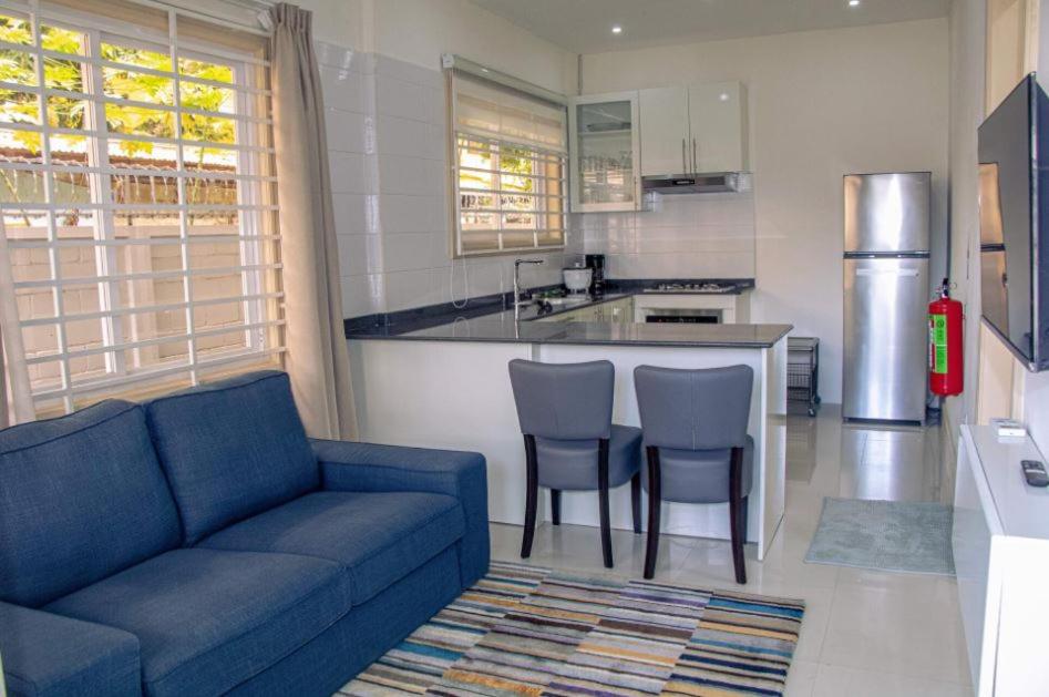 sala de estar con sofá y cocina en R&R Apartments en Paramaribo