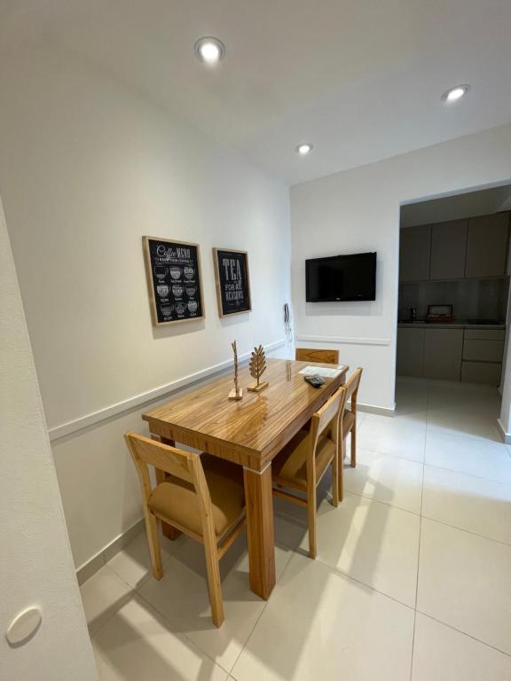 a dining room with a wooden table and chairs at Departamento céntrico y espacioso en Río Cuarto II in Río Cuarto