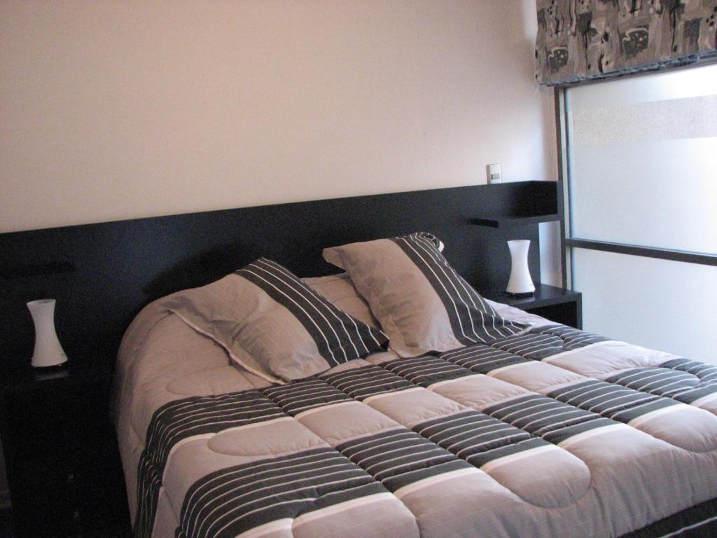 a bedroom with a large bed with a black headboard at loft barrio lastarria in Santiago