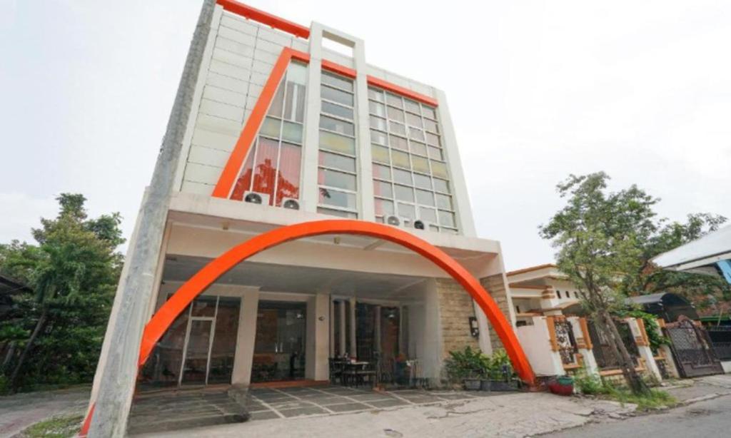 un edificio con un arco naranja delante de él en Semampir Residence By Occupied en Surabaya