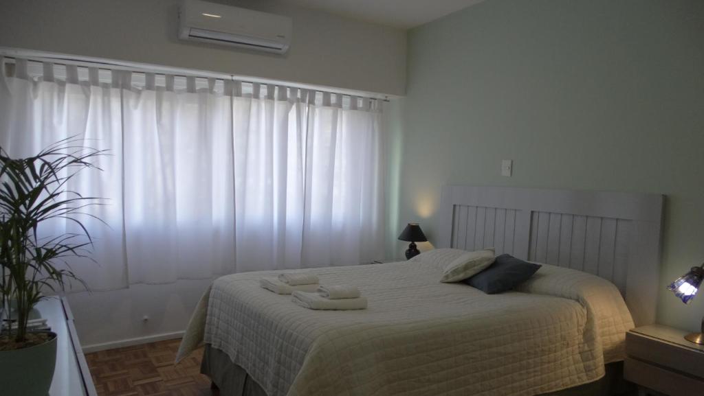 Adrogué的住宿－Monoambiente en pleno centro de Adrogué，一间卧室配有一张带白色床单的床和一扇窗户。
