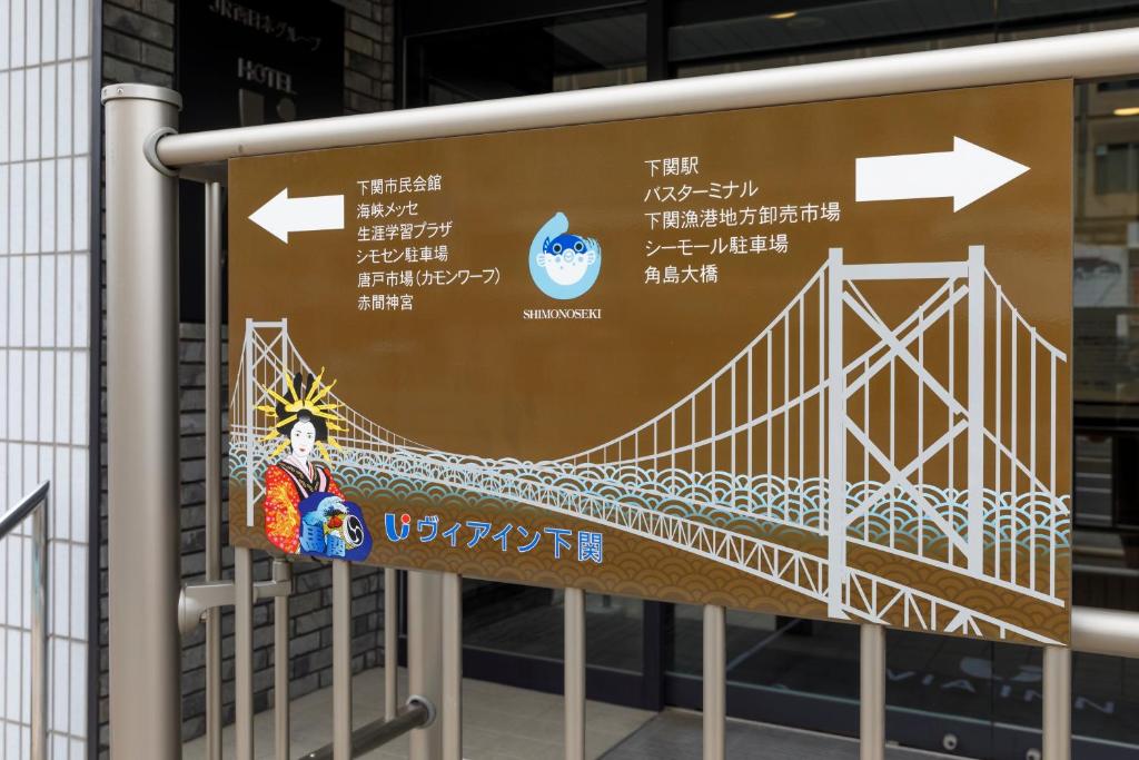 a sign with a bridge on it in front of a building at Via Inn Shimonoseki in Shimonoseki
