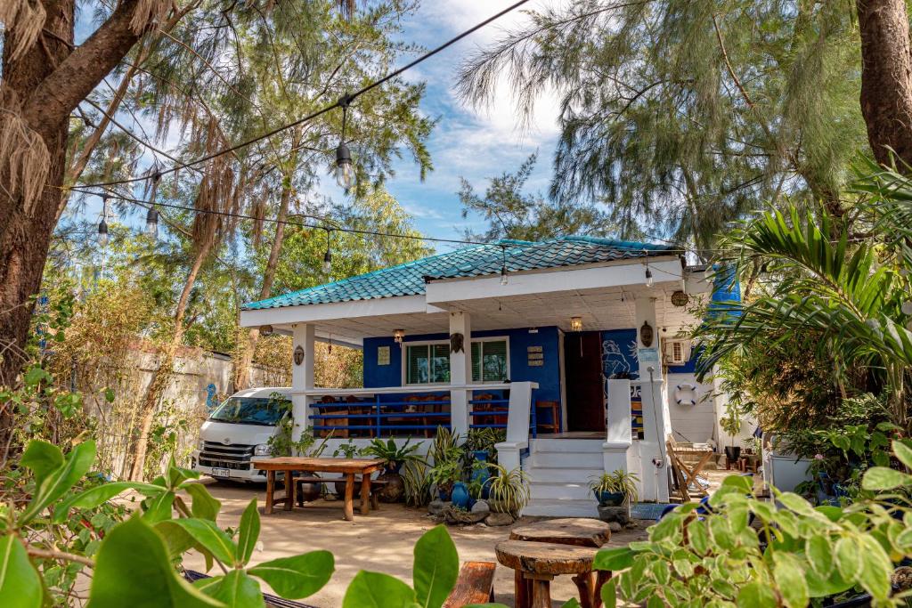 a blue house with a table and chairs in front of it at Azul Zambales Beachfront House & River Cottages EXCLUSIVE in Cabangan