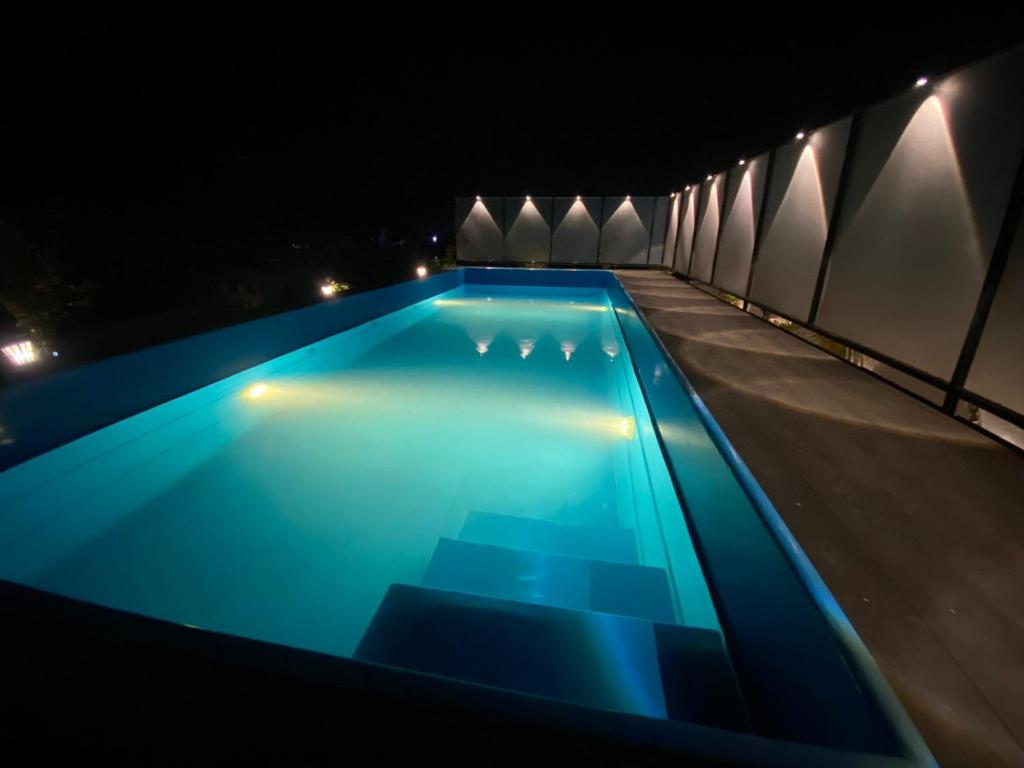 a swimming pool at night with blue lighting at Le Poshe Beachview in Puducherry