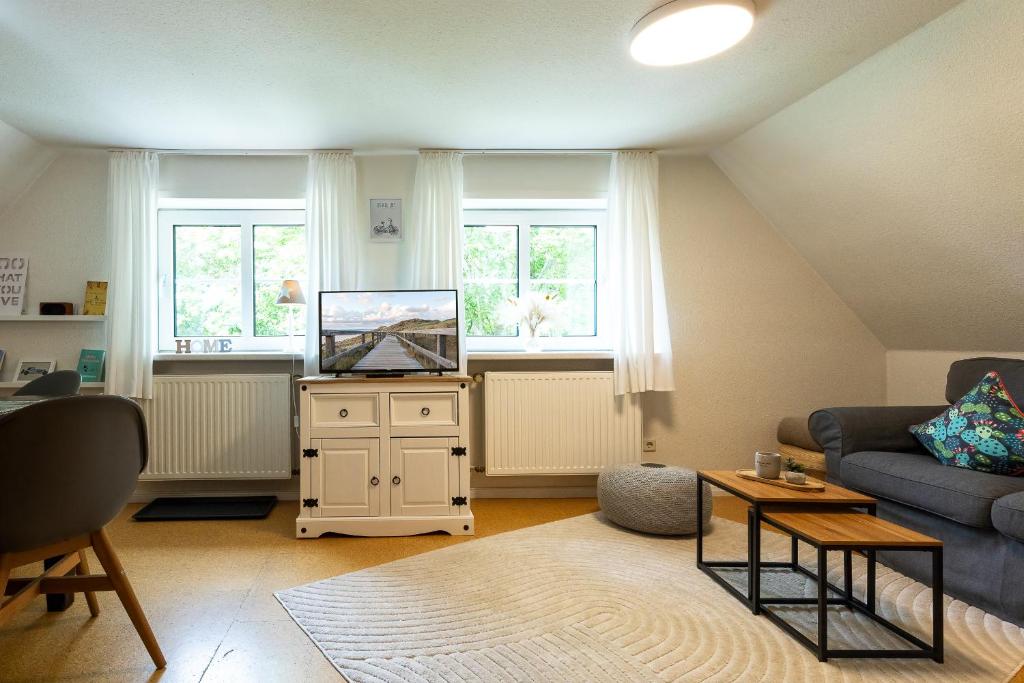 a living room with a couch and a tv at Appartement EBB in Morsum