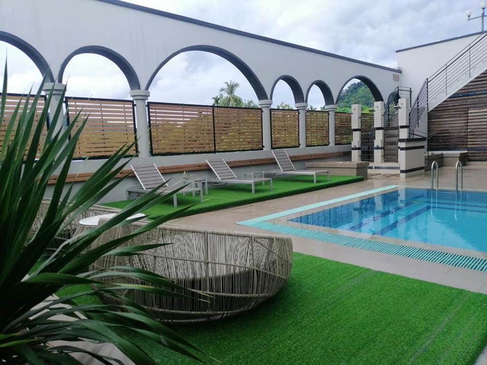 um pátio com piscina e relva verde em Langkawi Seaview Hotel em Kuah