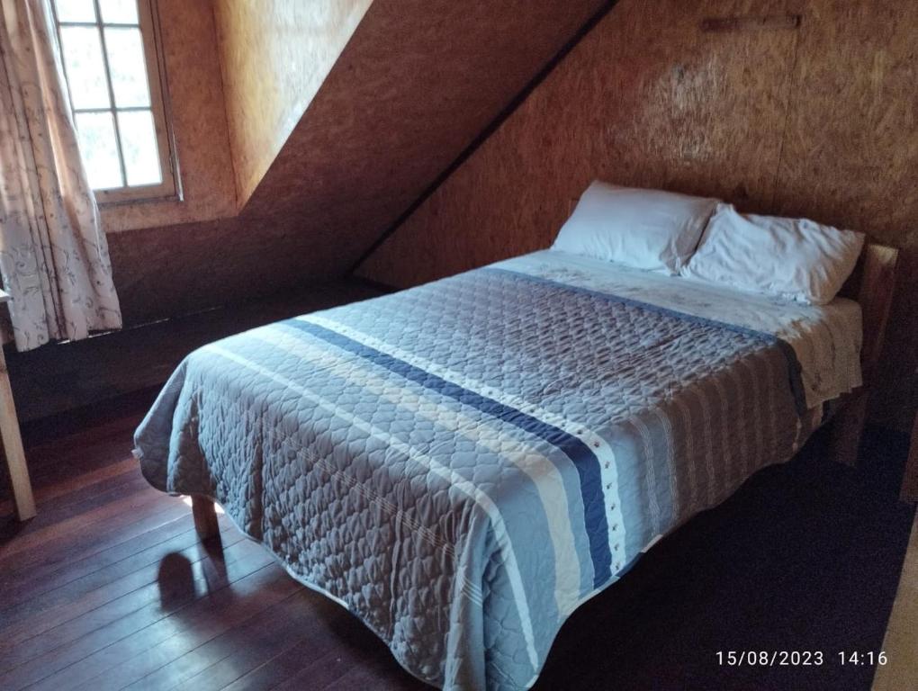 ein Schlafzimmer mit einem Bett mit einer blauen und weißen Decke in der Unterkunft Hospedaje Aurora in Oxapampa