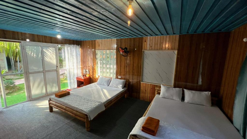a bedroom with two beds and a blue ceiling at Phu Nam House - Resort in Phú Quốc