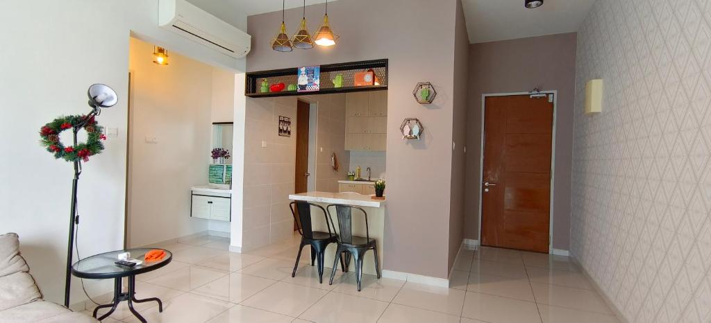een kleine keuken en een woonkamer met een tafel en stoelen bij Bukit Jalil City of Green Condominium 温馨小型舒服住所适合一家4口 in Seri Kembangan