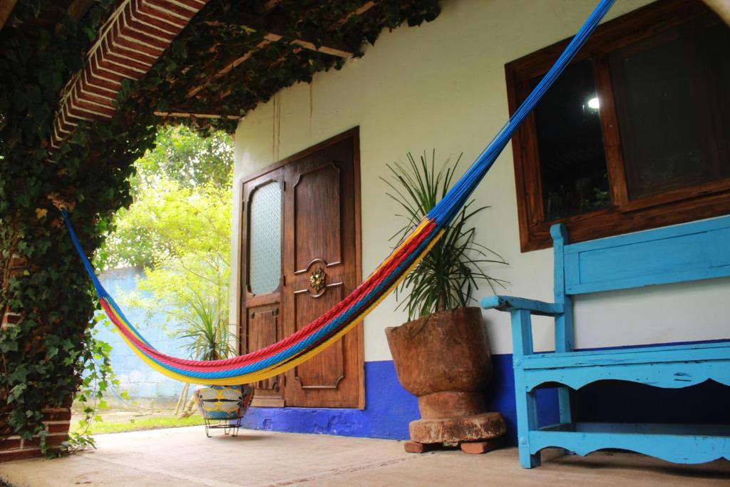 a hammock in front of a house with a door at habitación en medio de la naturaleza in Zacatlán