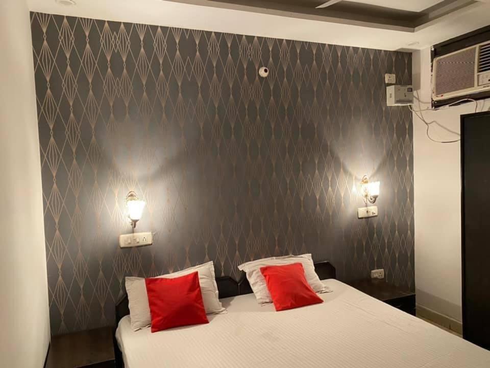 um quarto com uma cama com duas almofadas vermelhas em Hotel royal orbit em Zirakpur