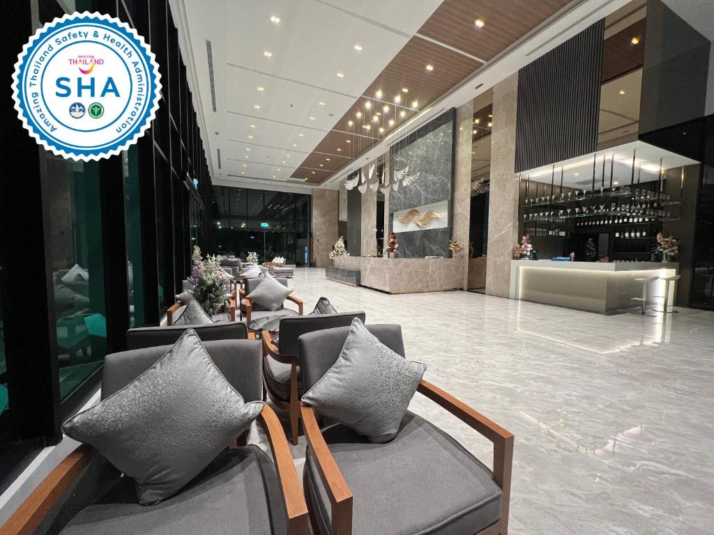 a lobby of a building with chairs and a store at Crystal Srivaree Suvarnabhumi Hotel in Ban Khlong Bang Krathiam