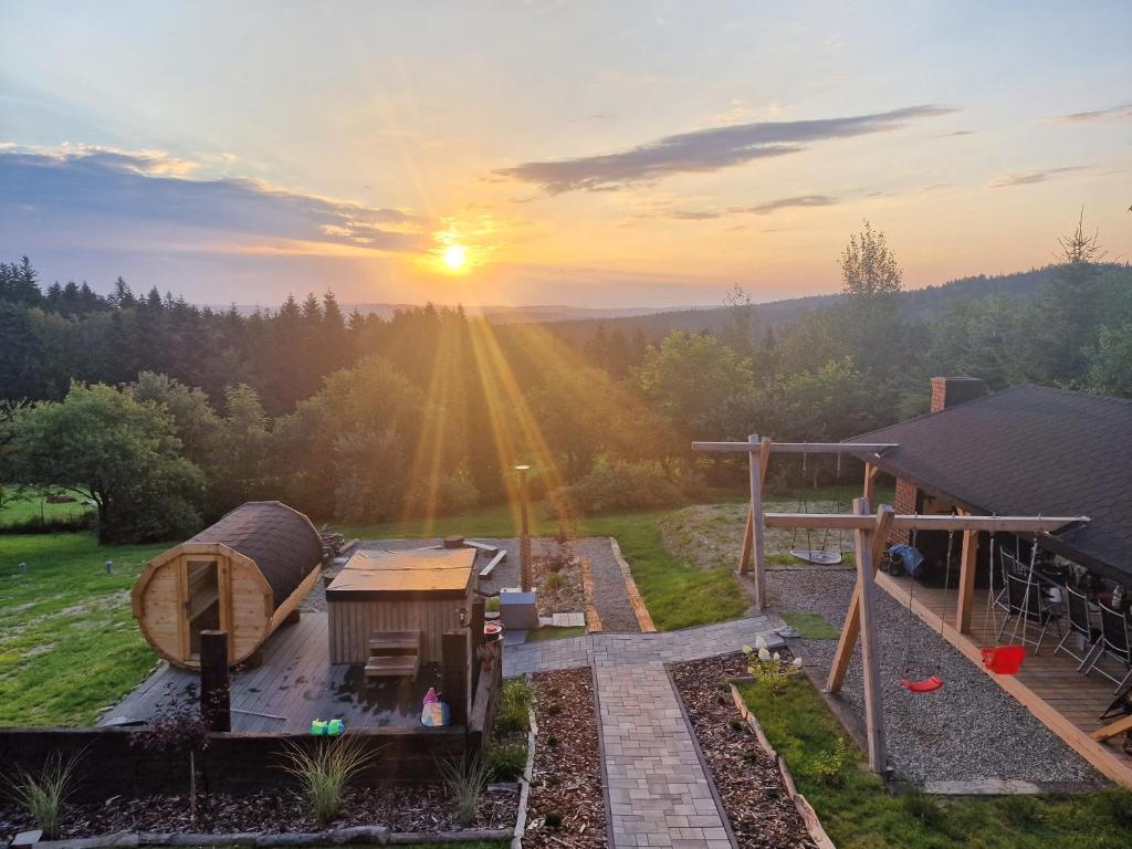 einen Blick auf einen Hinterhof bei Sonnenuntergang mit einem Baumhaus in der Unterkunft Beskidzki Zakątek Krynica-Zdrój in Krynica-Zdrój