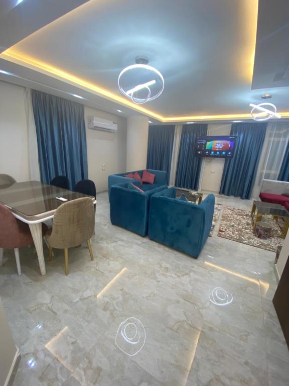 sala de estar con sofá azul y mesa en فندق وشقق المهندسين جامعه الدول العربية en El Cairo