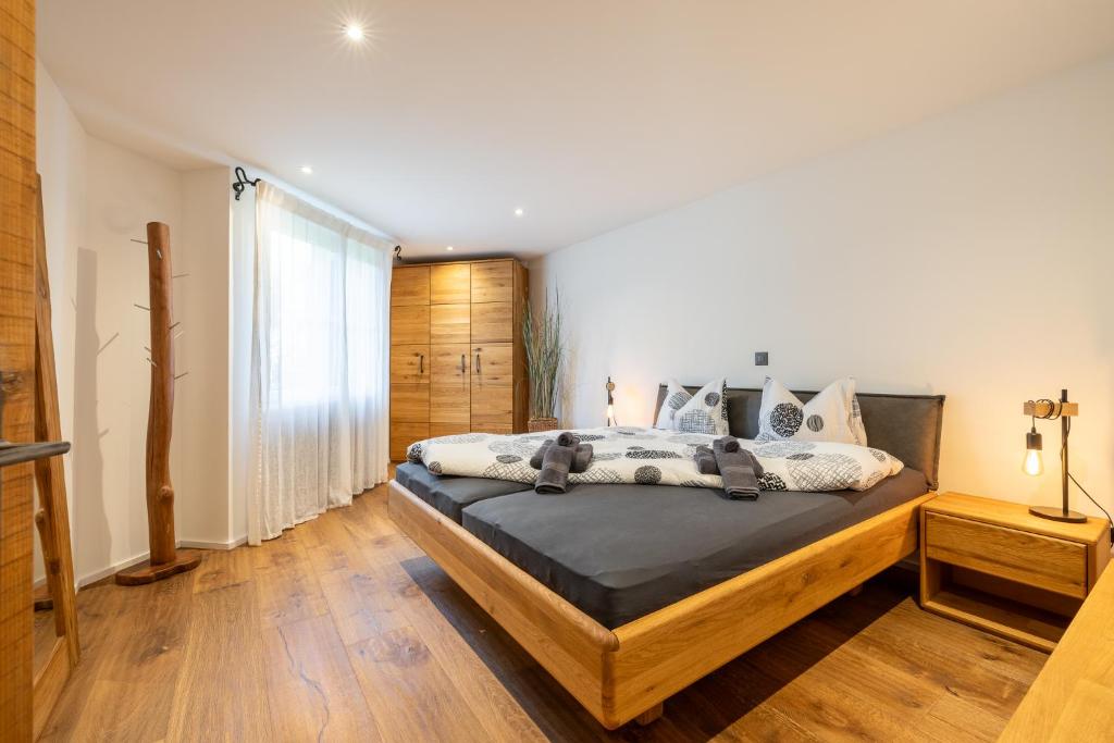a bedroom with a large bed with wooden floors at Chasa Valambrun 1004 in Vulpera