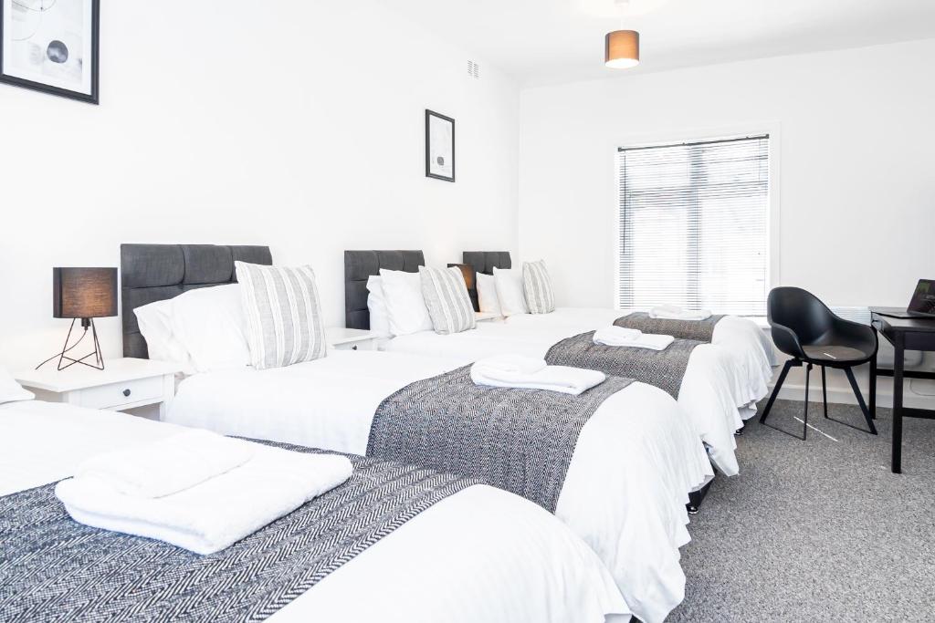 a group of four beds in a room at City Centre 3 Bed 8 Guest Parking Near Mayflower in Southampton