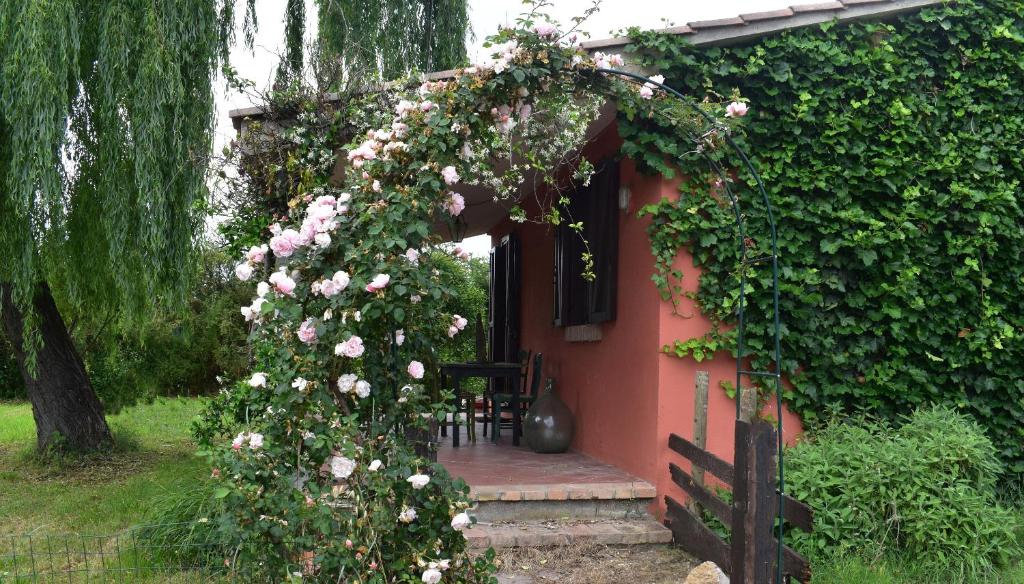 Una casa con un arco con rosas. en Cottage Oasi di San Martino, en San Martino in Colle