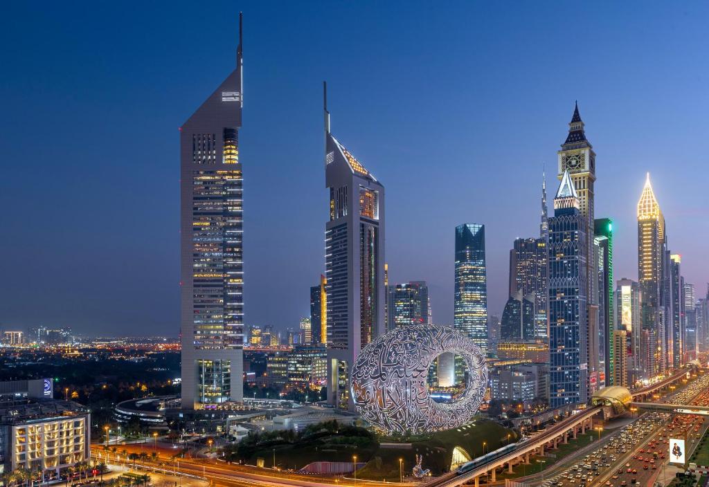 een skyline van de stad 's nachts met een reuzenrad bij Jumeirah Emirates Towers in Dubai