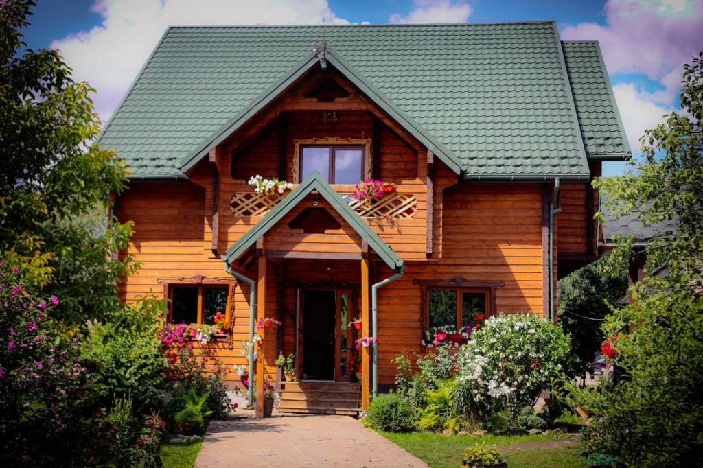 a log cabin with a porch and a window at Карпатське Щастя in Verkhovyna