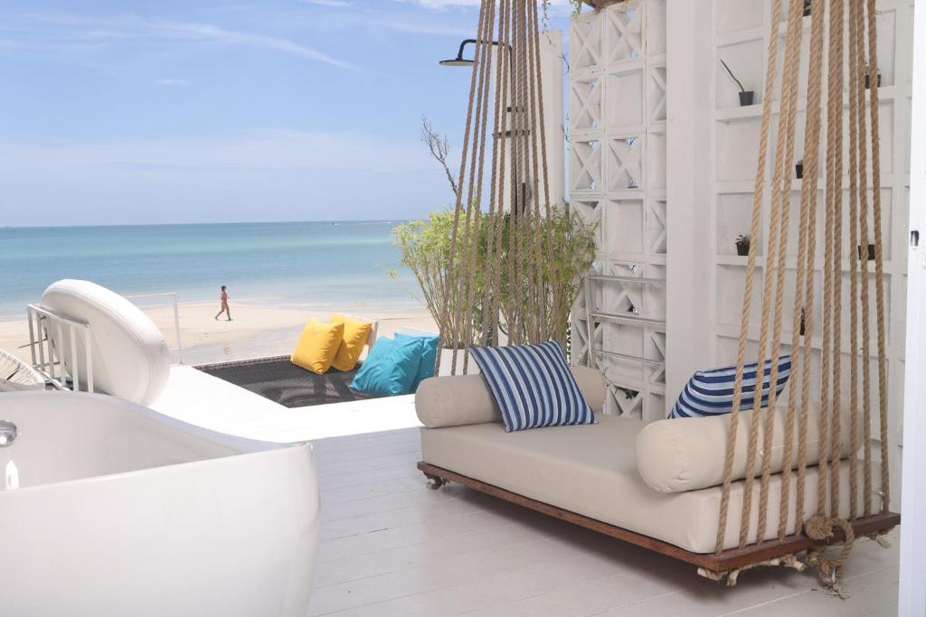 een veranda met een hangmat en uitzicht op het strand bij Adika - The beachfront Loft in Chaloklum