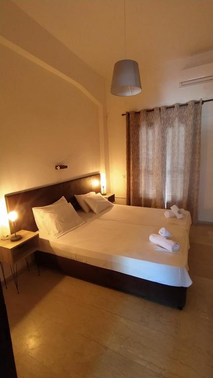 a bedroom with a large bed with towels on it at Perix House in Neos Marmaras