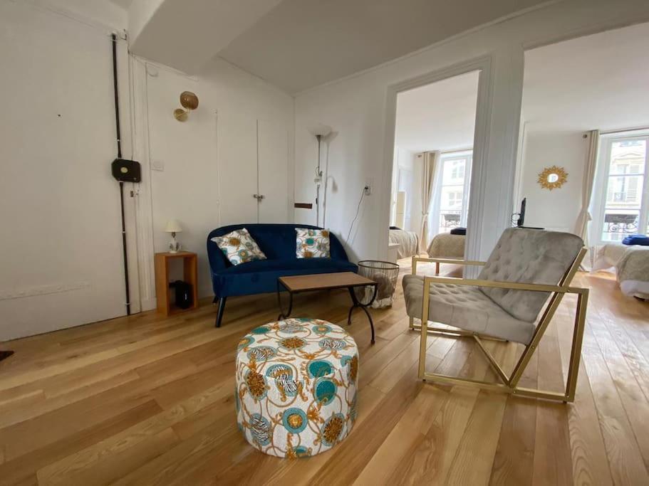 uma sala de estar com um sofá azul e uma cadeira em Coeur de Versailles Notre Dame - 3 pièces em Versailles