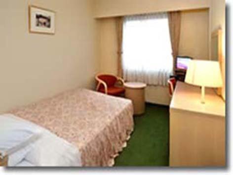 Habitación de hotel con cama y ventana en Matsuzaka Frex Hotel, en Matsusaka