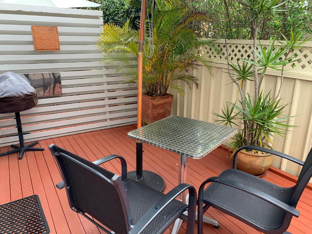 a patio with a table and chairs on a deck at Pelicans Rest Shellharbour in Shellharbour