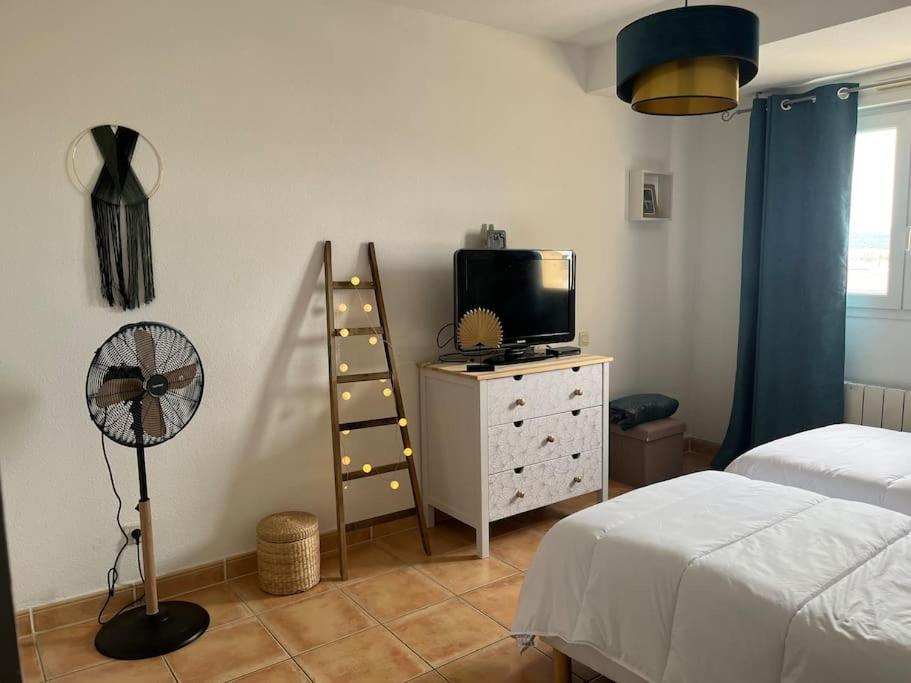 1 dormitorio con 1 cama, ventilador y TV en Cabane des Flamants YourHostHelper, en Gruissan