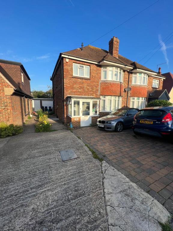 a brick house with two cars parked in a driveway at 29 park avenue in Shoreham-by-Sea