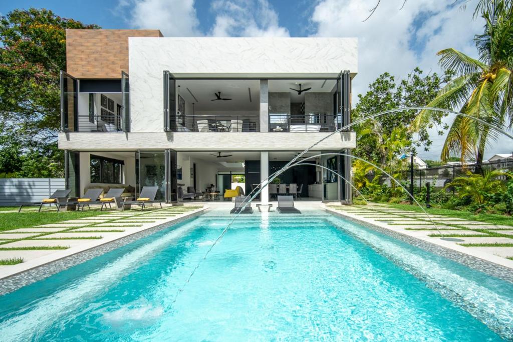 a villa with a swimming pool in front of a house at Onyx by Blue Sky Luxury in Saint James