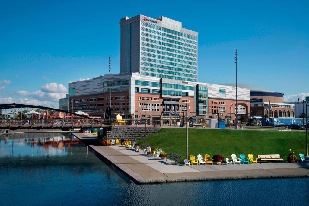 a city with a building and a river with chairs at Buffalo Marriott at LECOM HARBORCENTER in Buffalo