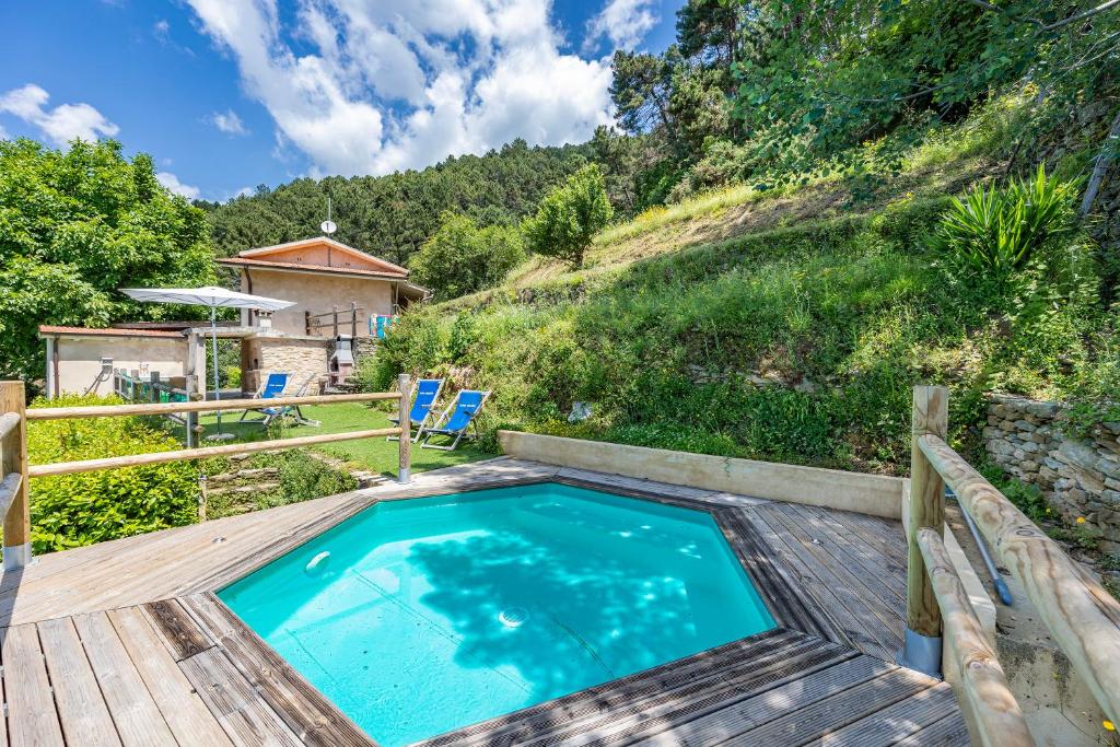 una piscina su una terrazza in legno con sedie e una casa di Casa Davide With Pool - Happy Rentals a Pietrasanta