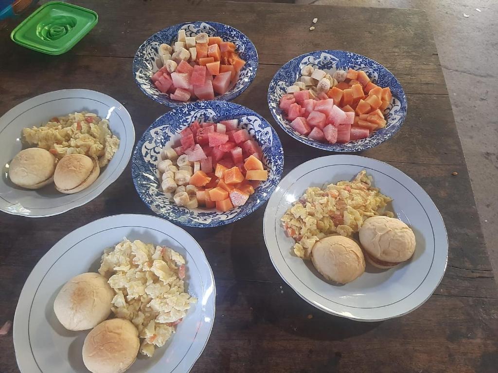 Quatre bols de nourriture sur une table avec des assiettes dans l'établissement RIUNG LALONG TERONG Guest House, à Riung