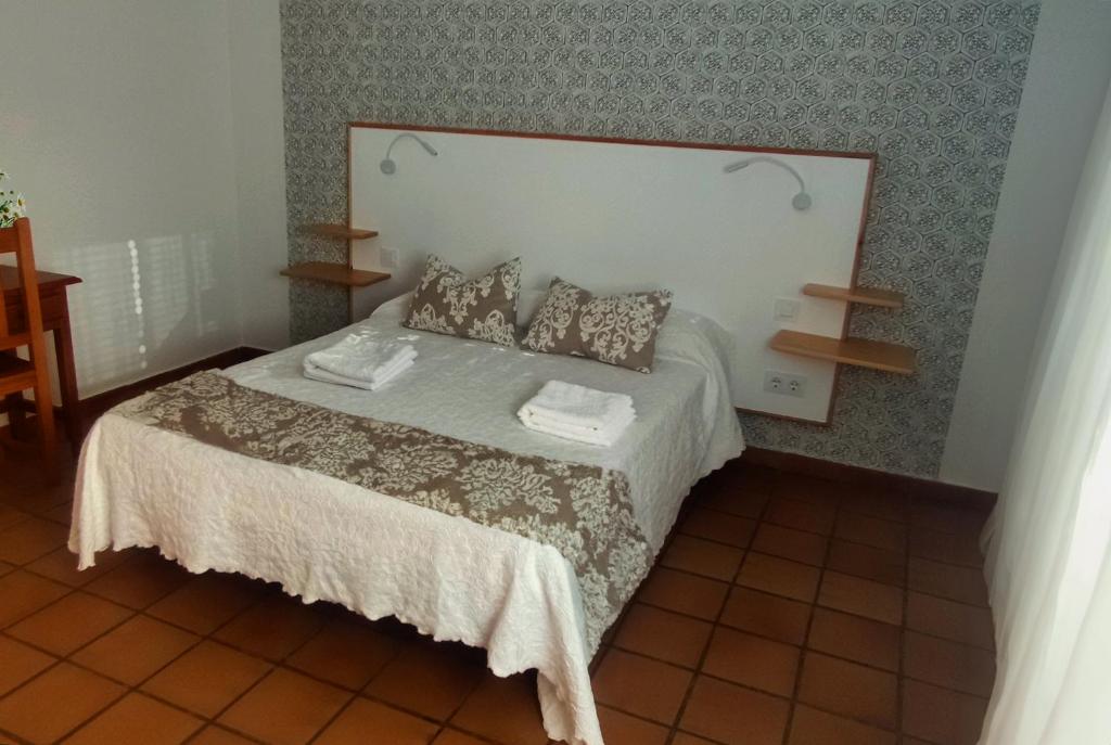 una camera con un letto con due cuscini sopra di Hostal Altamira Guadalupe a Guadalupe