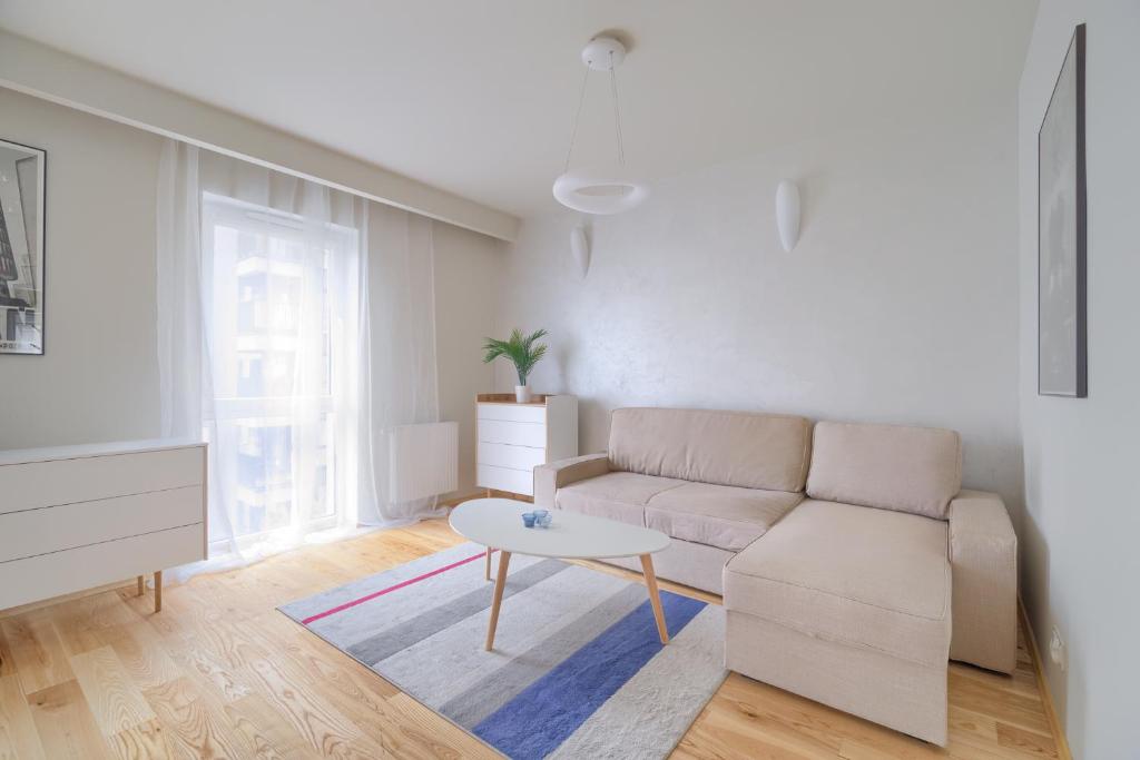 a living room with a couch and a table at Gąsiorowskich Beige Apartment in Poznań