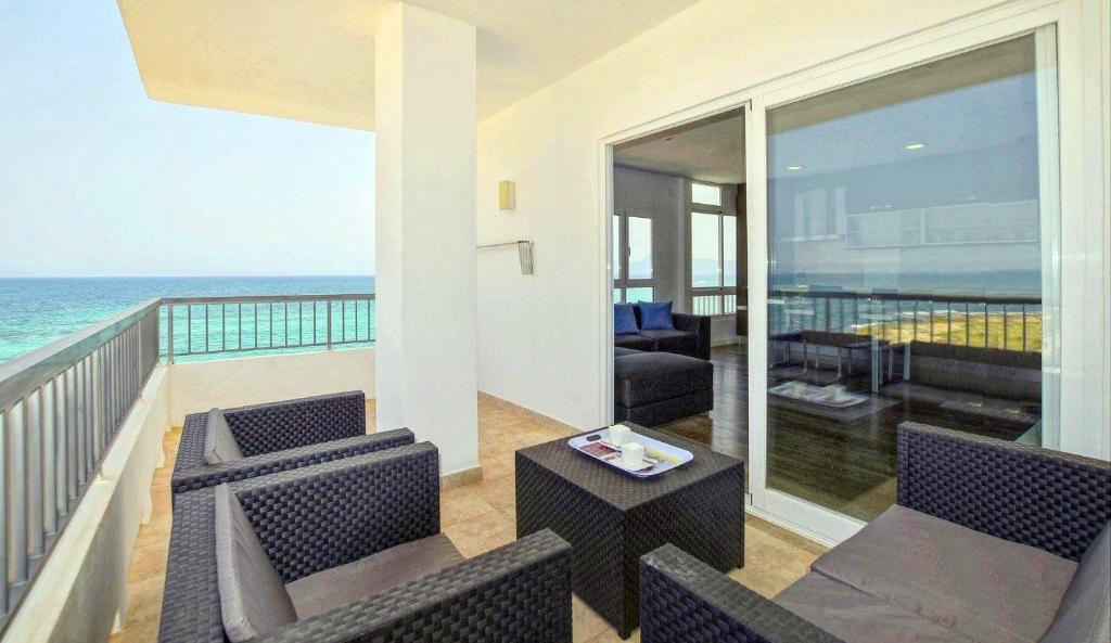 a living room with chairs and a balcony with the ocean at Son Baulo in Can Picafort