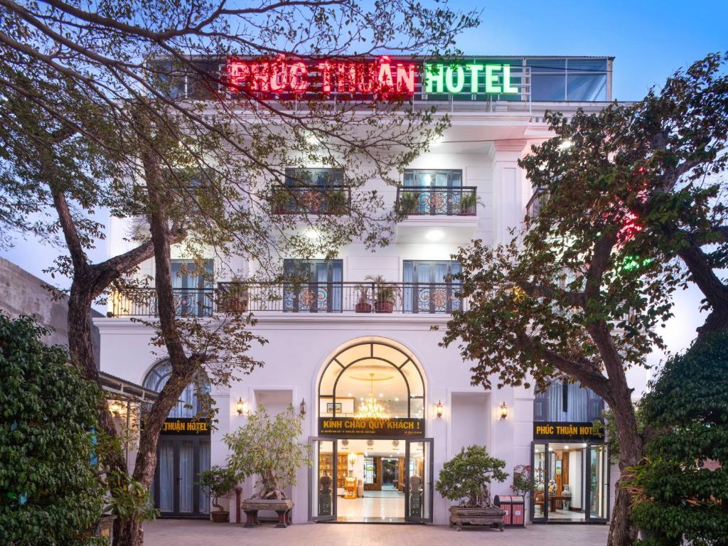 Un bâtiment blanc avec un panneau de néon sur lui dans l'établissement Phúc Thuận Hotel, à Phan Rang