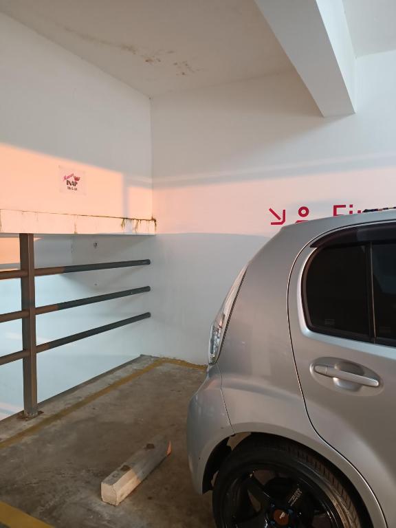 關丹的住宿－Timurbay Seafront Residence Mawar Inap Homestay，把车停在车库里,上面写着你在墙上租用的字眼