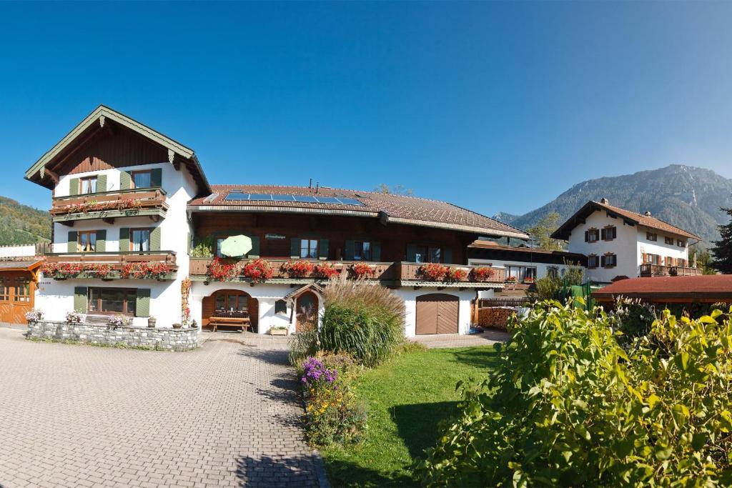 een groot wit huis met bloemen in de tuin bij Ferienwohnungen Gastager in Ruhpolding