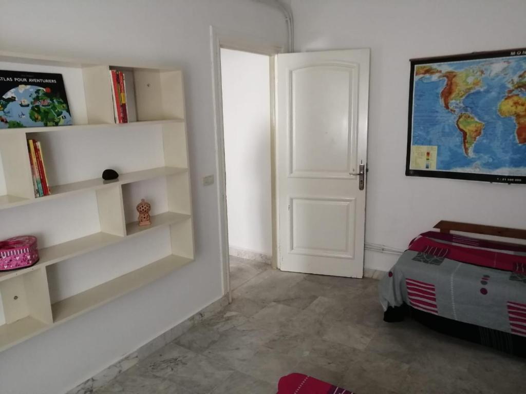 una habitación con estanterías blancas y una puerta en JasminVilla, en Sousse