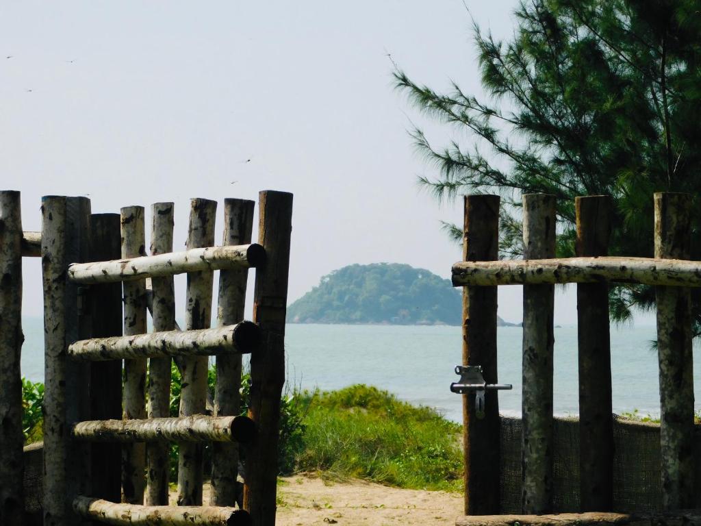 uma cerca de madeira ao lado de uma massa de água em Lagi Retreat homestay Home ngay mặt biển Lagi em La Gi