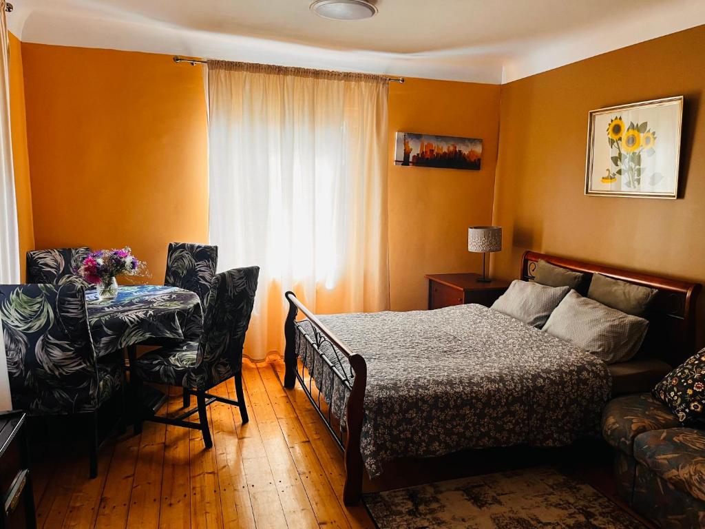 a bedroom with a bed and a table and a window at Unique Mailo cottage in Rīga