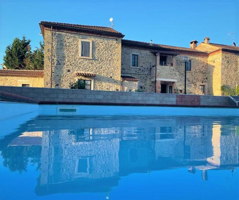 een gebouw met een waterbad ervoor bij Podere La Selva in Rapolano Terme